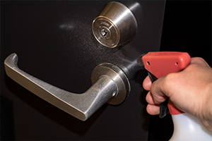 ドアノブに強酸性水を吹きかける様子